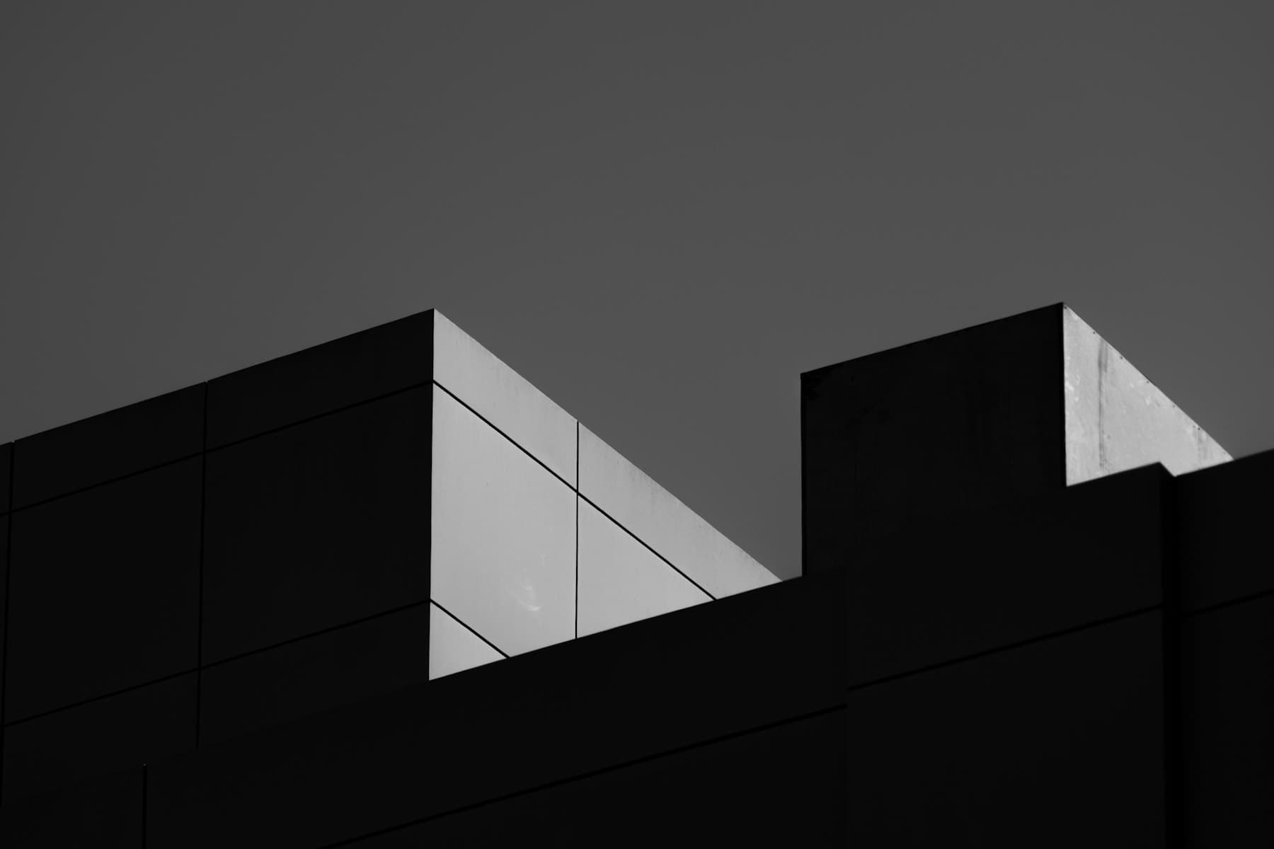 A modern concrete building facade in strong geometric light and shadow